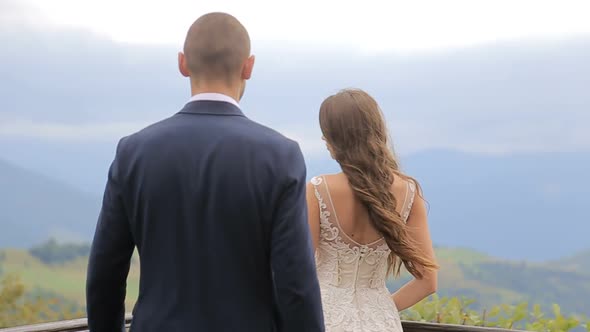 Happy Brides Bride and Groom Overlooking Beautiful Green Mountains