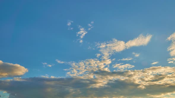 Blue Sky with Floating Clouds Illuminated By Sun During Sunset