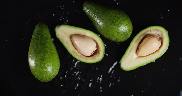 Falling Cut Fresh Avocados in the Water