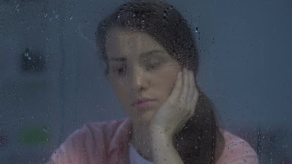 Unhappy Depressed Lonely Lady Sitting Behind Rainy Window, Suffering Divorce