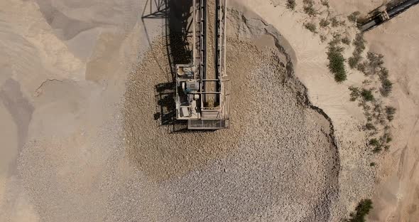 Stone sorting station in a large Quarry, with rocks transported on conveyor belts, Aerial view.