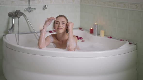 Wide Shot of Confident Relaxed Caucasian Slim Young Woman Posing in Bathtub at Home Indoors