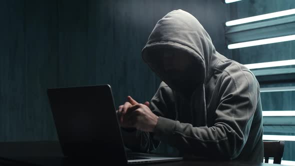 Unrecognizable Hacker Man Stretching Hands and Starting To Typing on Laptop and Breaking Password