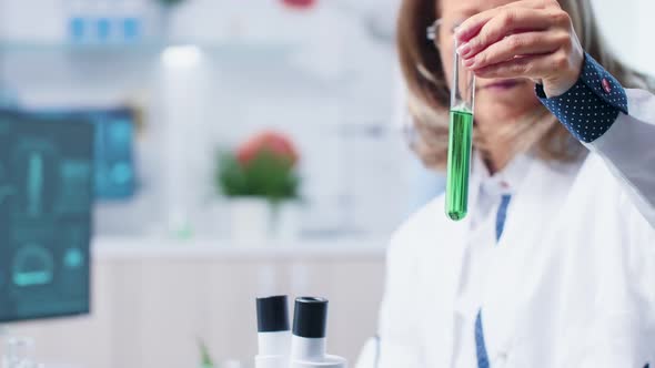 Female Scientist Looking at Green Bio Sample