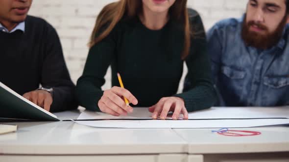 Young Attractive Woman is Drawing a Plan Using Straightedge and Paper