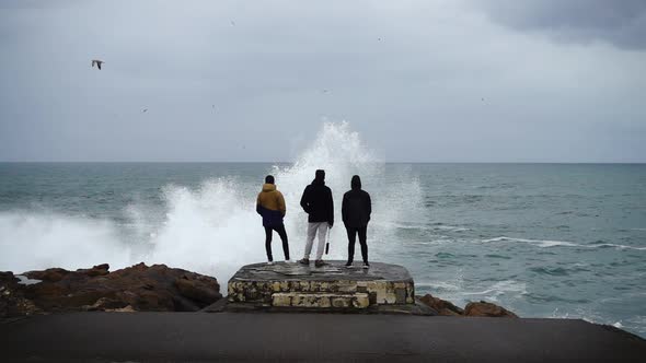 Young Guys Look at Waves in the Ocean