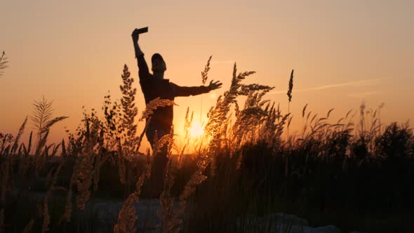 The Happiest Person Herself. Silhouette Of A Happy Man With A Smartphone In His Hand Taking A Selfie