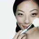 Young woman using make up brush on face - VideoHive Item for Sale