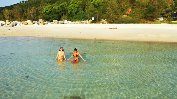 Beautiful women happy together on paradise shore beach holiday by aqua blue ocean and white sand bac