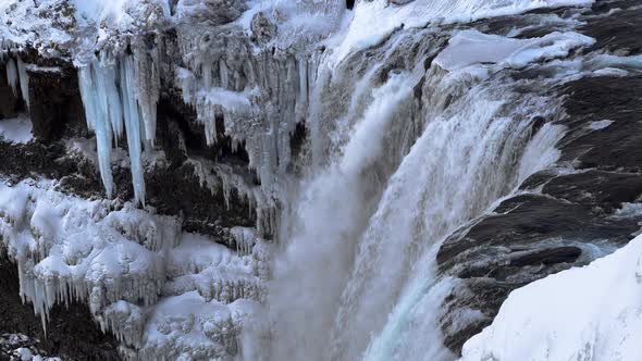 Slow motion shot of giant deluge of water flowing down icy waterfall in Iceland