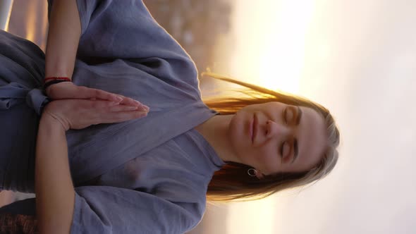 Peaceful Blonde Woman Standing on Terrace with Closed Eyes Namaste Gesture