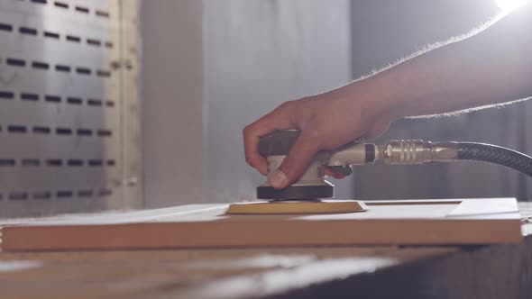 Slow motion of a worker polishing a cabinet door in a furniture factory