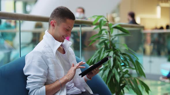 Cheerful Man Using Tablet in Shopping Mall