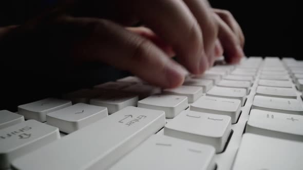 Close-up typing on keyboard with man fingers. Macro soft focus dolly shot.