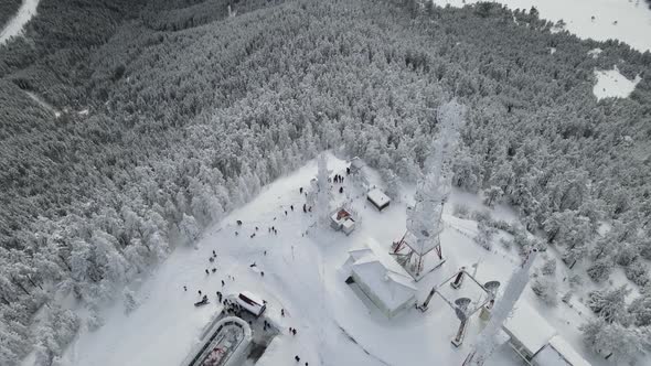 Transmitter repeater with antennas on the top of the mountain covered with snow. Ski lift, people an