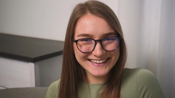 Confident Laughs Young Woman in Glasses Looking at Camera Standing at Home Office