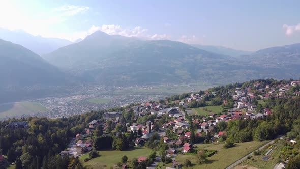 Aerial tilt down over a small village in the french Alps, Plateau d'Assy. Backlighting and autumn co