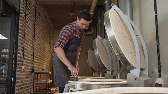 Middle Age Male Potter Putting Clay Pots for Firing in the Oven.