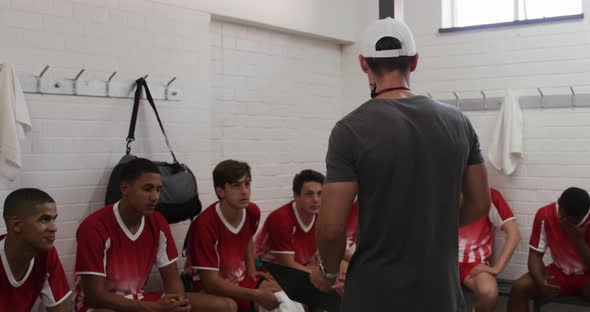 Coach talking to rugby players in the locker room