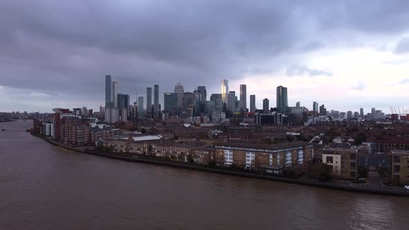 Aerial shot of Canary Wharf and City of London skyline with stormy clouds