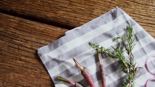 Carrots, rosemary and onion rings on napkin 4k