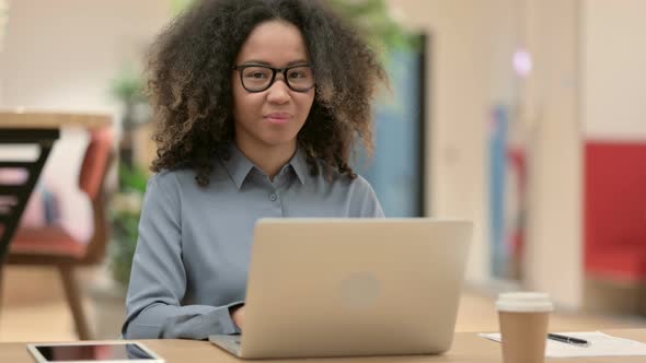 Young African Woman Using Laptop with Thumbs Up Sign