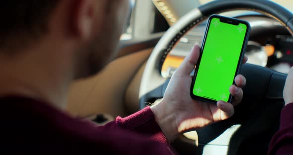 Man Using Smartphone with Green Screen Chroma Key Inside Car