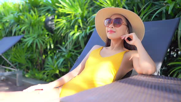 Young asian woman enjoy around outdoor swimming pool for leisure