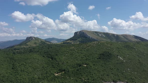 Ascending over the forest and hills under Carpathian Stol mountain 4K aerial video