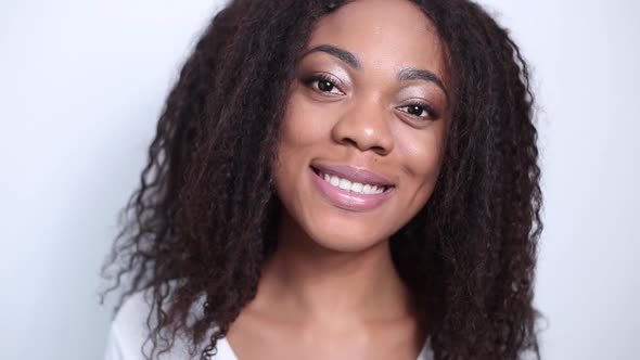 Portrait of a smiling African American young woman with curly hair.