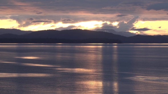 Sea cruise ship along the coast of Alaska. Colorful sunset in the mountains of Alaska.