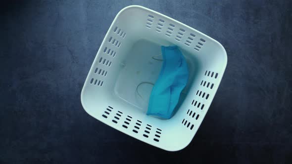 Used Disposable Face Mask and Gloves in Plastic Bin