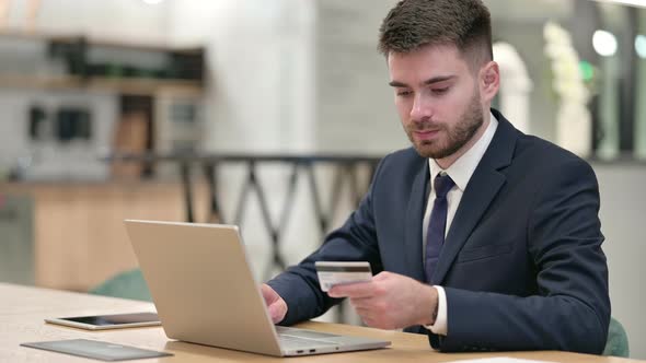 Online Payment Success on Laptop for Young Businessman in Office 
