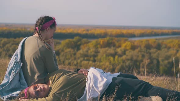 Young Lesbian Couple Rests After Hike on Autumn Grass