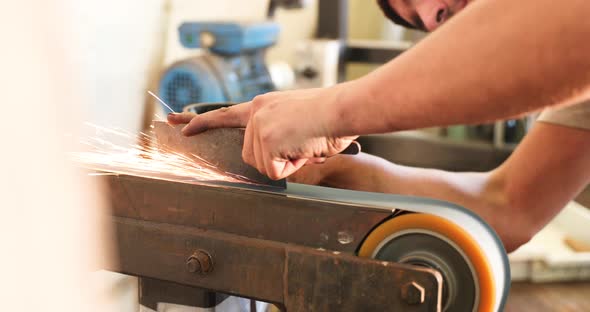 Bladesmith grinding a blade at belt grinder