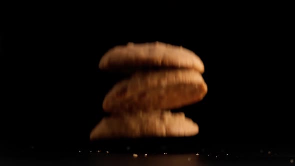 Stack of cookies falling on table.