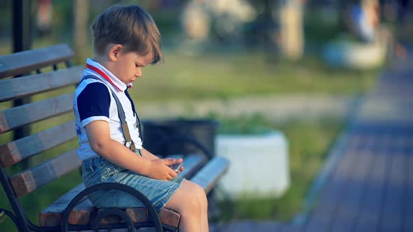 Child Playing with Smart Phone in the Park Outdoors