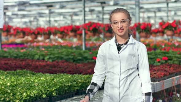 Positive Young Female Agricultural Engineer Enjoying Working Posing in Greenhouse Medium Shot