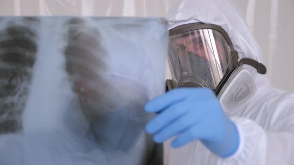 Doctor with Protective Suit Checking Examining Chest Xray Film of Patient