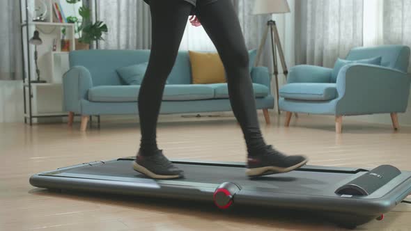 Side View Legs Of Asian Woman Training On Walking Treadmill At Home