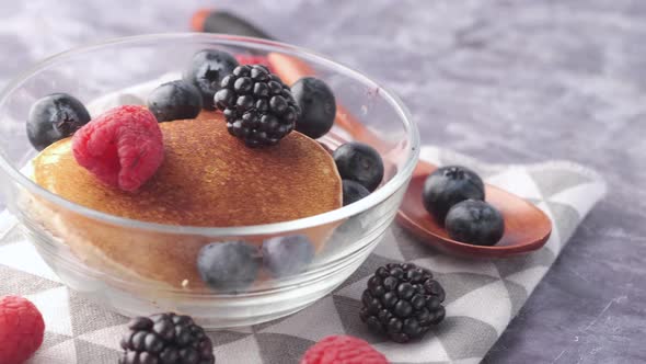 Tasty Meal with Berries and Pan Cake in Bowl on Black Background