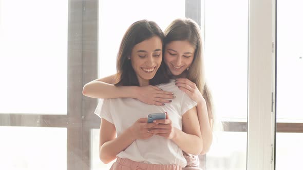 Two Sisters Having Online Chat with Friends