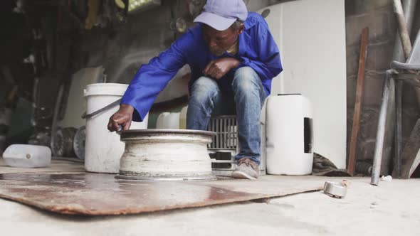 Old African handyman making an object