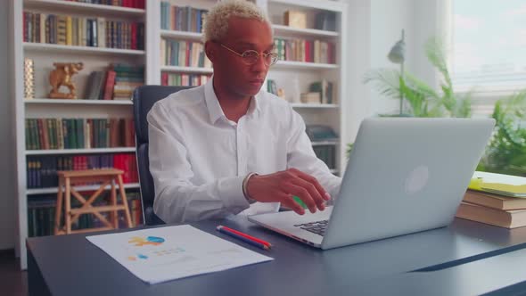 Serious African American Businessman Prepares Data for a Marketing Report