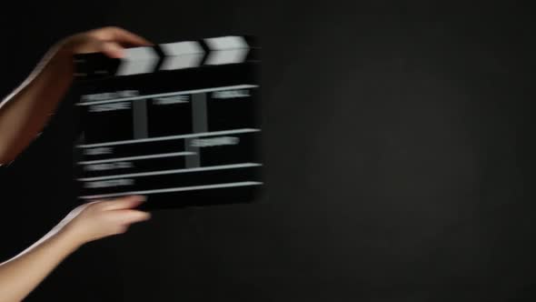 Hands with Movie Production Clapper Board, on Black