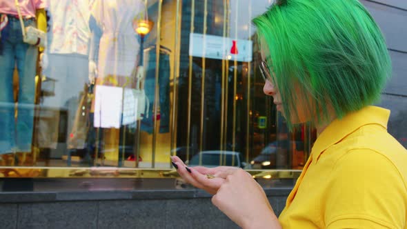 A Woman Counting Money in Front of a Shop Window