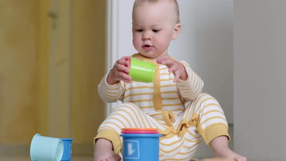 Little Baby Playing with Educational Colorful Toys at Home Sitting on Floor