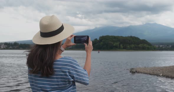 Woman take photo on cellphone when hiking