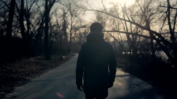 Lonely Businessman On Jacket Walking At Fall.Confidence Man Walking On Autumn Road At Sunset