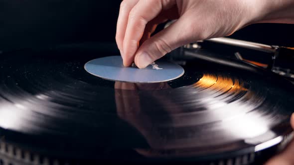 Person Puts a Vinyl Record on a Player and Turns It On